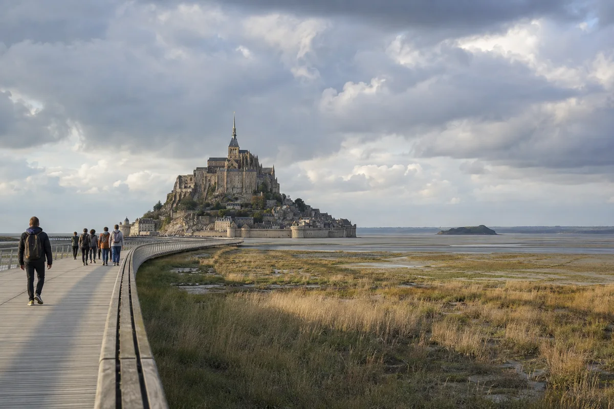 Visitors approaching Mont-Saint-Michel along the causeway beside the bay